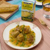 Albondigas a la jardinera en salsa con guisantes y zanahoria, acompañadas de pan y caldo de verduras.