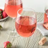 Dos copas de vino rosado y fresas frescas, un vistazo a como se hace el vino rosado.