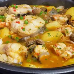 Merluza a la cazuela con patatas, gambas y berberechos, un plato marinero reconfortante y lleno de sabor.