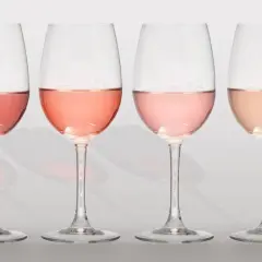 Cuatro copas de vino con diferentes tonos de clarete o rosado, desde un rosa intenso hasta un salmón pálido.