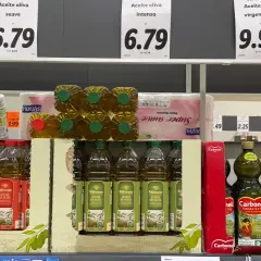 Estanterías de supermercado con varias botellas de aceite de oliva. El precio del aceite de oliva suave es de 6.79, el intenso también 6.79 y el virgen extra 9.90.