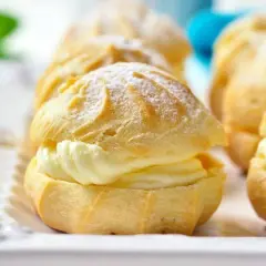 Profiteroles rellenos de crema pastelera Thermomix, espolvoreados con azúcar glas. Deliciosos y fáciles de preparar.