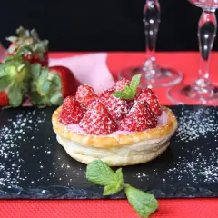 Tarta de fresas con crema rosa, espolvoreada con azúcar glas y menta. Perfecta para acompañar vinos de postre.