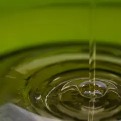 Gota de aceite cayendo en un líquido, creando ondas. El aceite de oliva refinado es malo para la salud.
