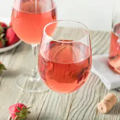 Dos copas de vino rosado y fresas frescas, un vistazo a como se hace el vino rosado.