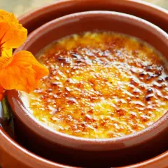 Crema catalana con una flor naranja. Una delicia para tu crema catalana receta.