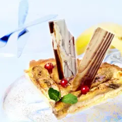 Deliciosa tarta de plátano con trozos de chocolate y frutos rojos, lista para disfrutar.