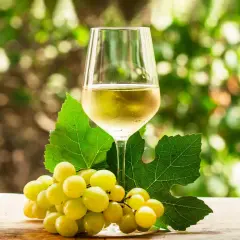 Copa de vino blanco con uvas verdes y hojas, evocando la diferencia entre Rueda y Verdejo.