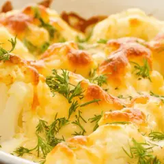 Coliflor al horno gratinada con queso y hierbas frescas, un plato reconfortante y delicioso.