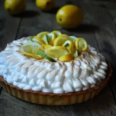 Deliciosa tarta de limón con merengue dorado y rodajas de limón fresco.
