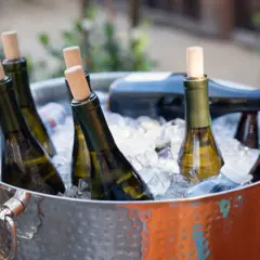 Botellas de vino blanco en cubitera de hielo, listas para disfrutar a la temperatura perfecta.