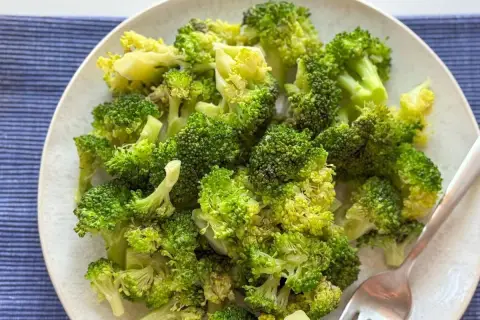 Un plato de brócoli cocido, verde brillante y tierno, listo para disfrutar.