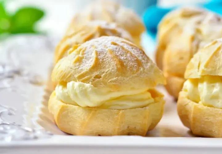 Profiteroles rellenos de crema pastelera Thermomix, espolvoreados con azúcar glas. Deliciosos y fáciles de preparar.