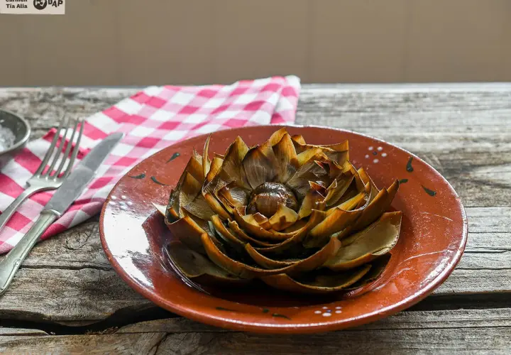 Alcachofas al horno, doradas y tiernas, listas para disfrutar en un plato rústico.