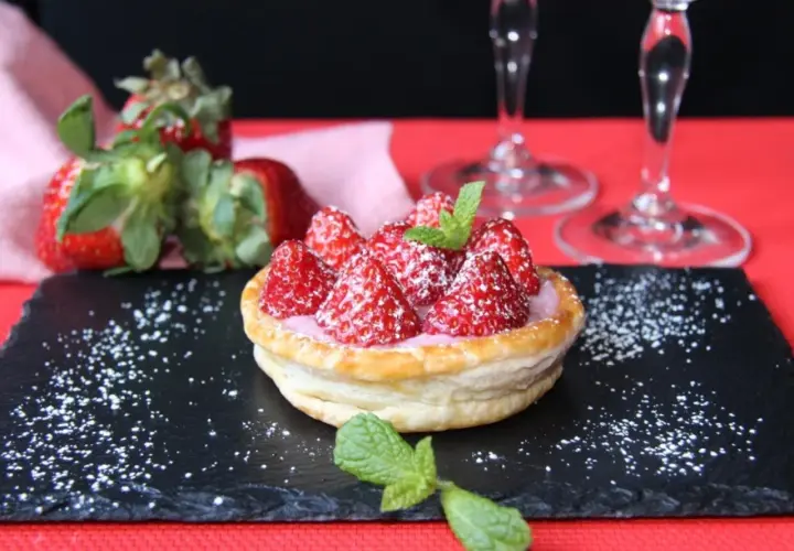 Tarta de fresas con crema rosa, espolvoreada con azúcar glas y menta. Perfecta para acompañar vinos de postre.