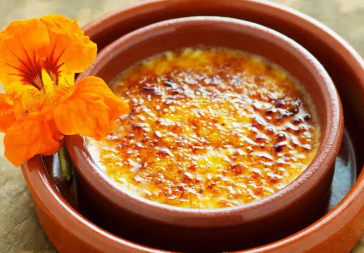 Crema catalana con una flor naranja. Una delicia para tu crema catalana receta.