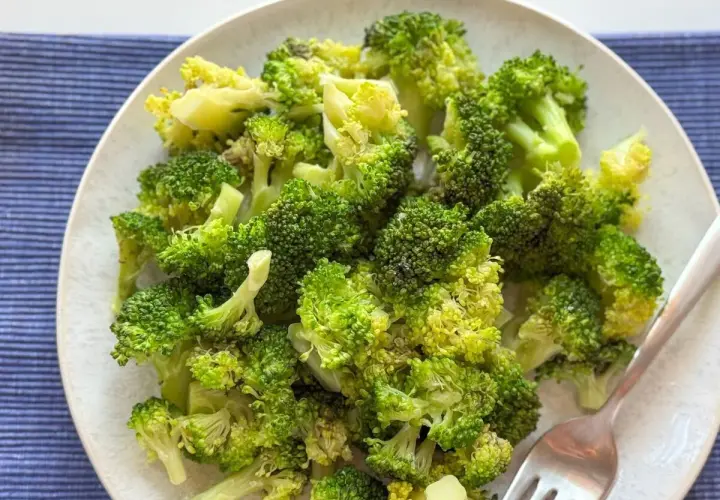 Un plato de brócoli cocido, verde brillante y tierno, listo para disfrutar.