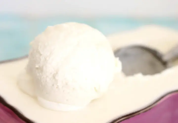 Una bola cremosa de helado de nata sobre un plato, lista para ser disfrutada.