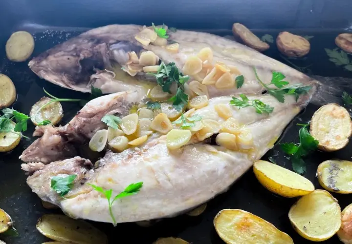 Dorada a la espalda, jugosa y tierna, con patatas asadas y un toque de ajo y perejil.
