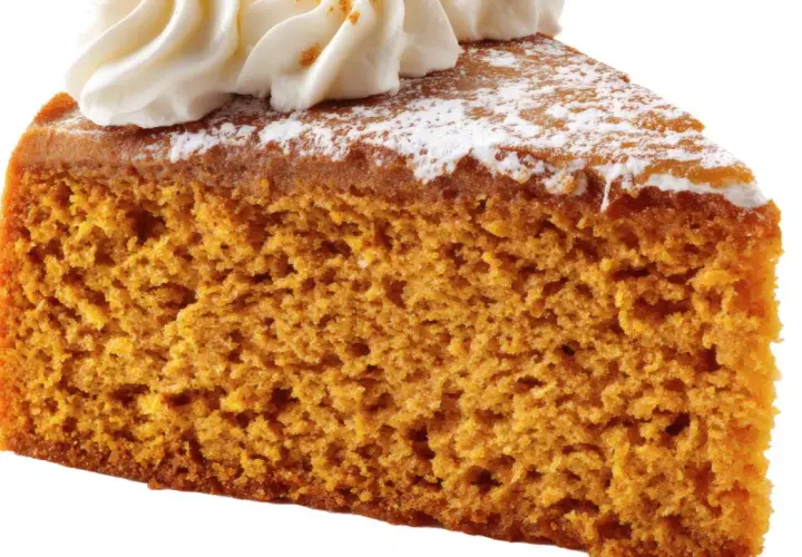 Rebanada de bizcocho de calabaza esponjoso, cubierto con crema batida y espolvoreado con azúcar glas.