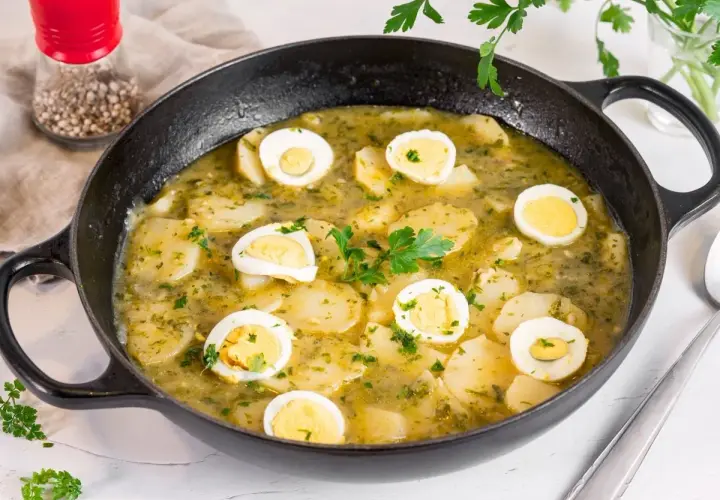 Patatas en salsa verde con huevos duros, un plato reconfortante y lleno de sabor, listo para disfrutar.