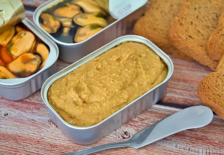 Pate de mejillones en lata, junto a mejillones en escabeche y tostadas.