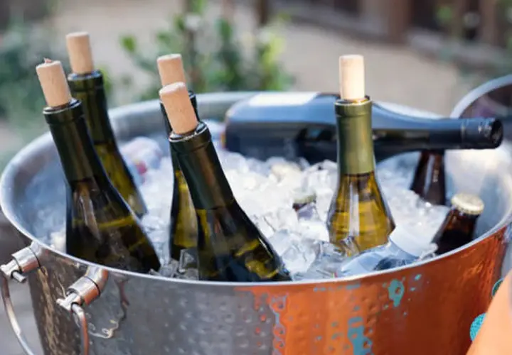 Botellas de vino blanco en cubitera de hielo, listas para disfrutar a la temperatura perfecta.