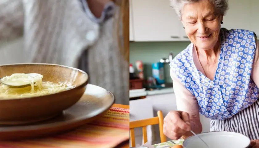 Abuela sonriente prepara sopa de fideos casera. Un plato humeante espera ser disfrutado.