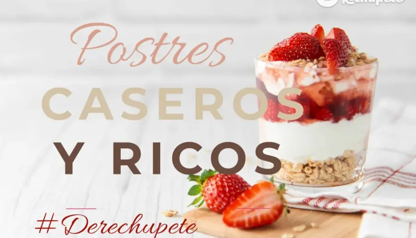 Vaso de postre de fresa y yogur con granola, junto a fresas frescas.