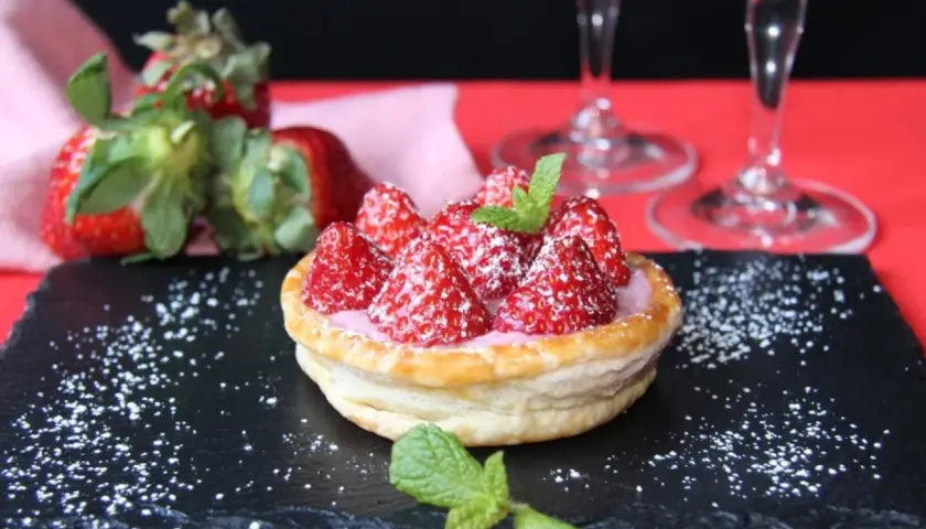 Tarta de fresas con crema rosa, espolvoreada con azúcar glas y menta. Perfecta para acompañar vinos de postre.