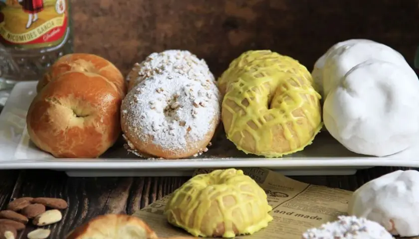 Rosquillas tontas, algunas cubiertas de azúcar glas y almendras, otras con glaseado amarillo y unas blancas. ¡Un dulce tentempié!