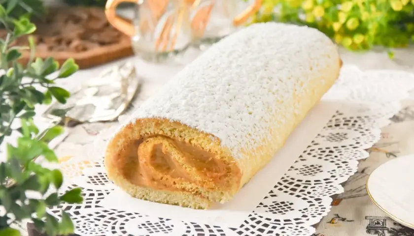 Un delicioso brazo de gitano cubierto de azúcar glas, listo para ser disfrutado.