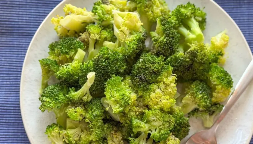 Un plato de brócoli cocido, verde brillante y tierno, listo para disfrutar.
