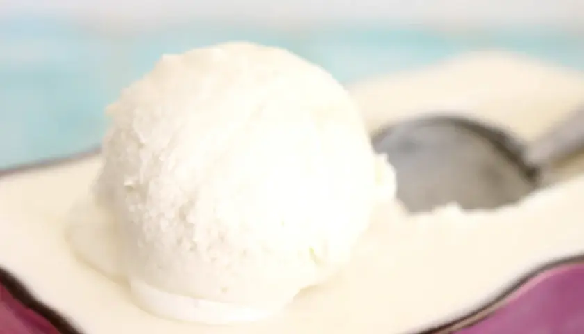 Una bola cremosa de helado de nata sobre un plato, lista para ser disfrutada.