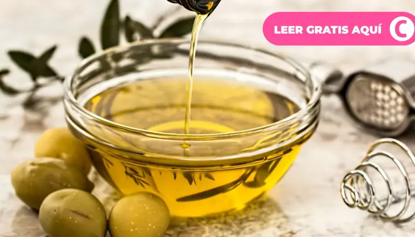 Aceite de oliva vertiéndose en un cuenco, rodeado de aceitunas y hojas de olivo. Descubre los múltiples usos del olivo.