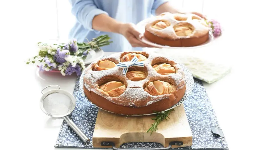 Deliciosa tarta de manzana Thermomix, espolvoreada con azúcar glas y decorada con un lazo azul.