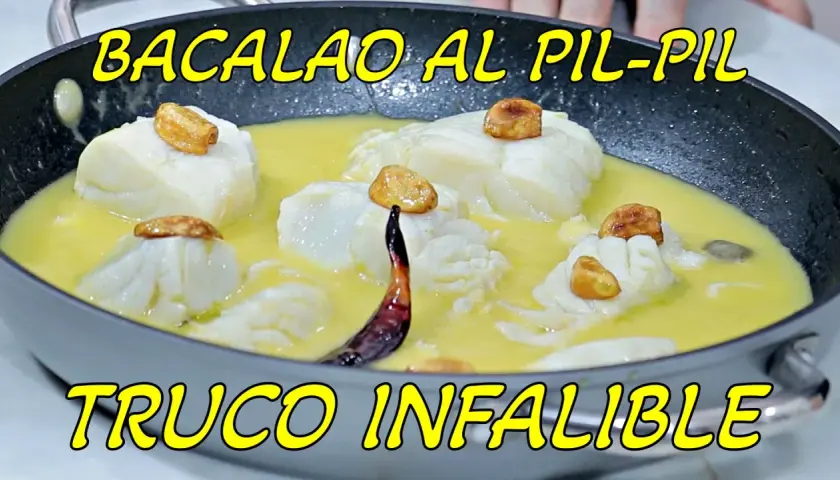 Bacalao al pil pil en sartén, con trozos de pescado blanco, ajos dorados y una guindilla. ¡La receta infalible!