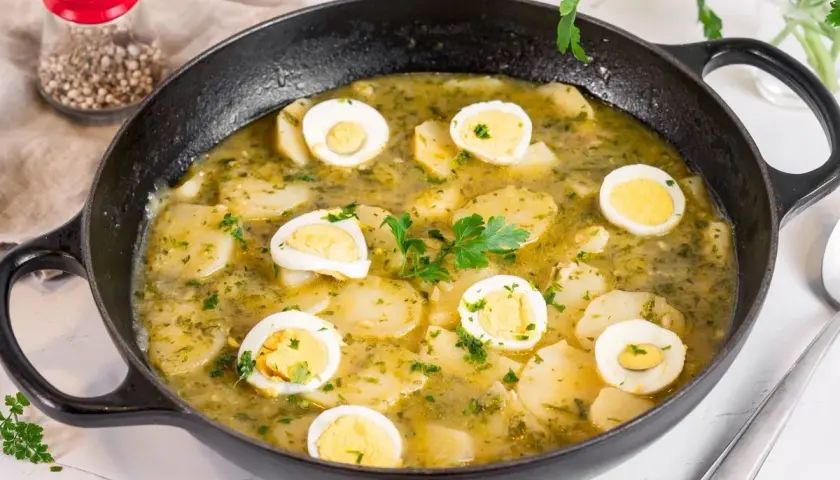 Patatas en salsa verde con huevos duros, un plato reconfortante y lleno de sabor, listo para disfrutar.
