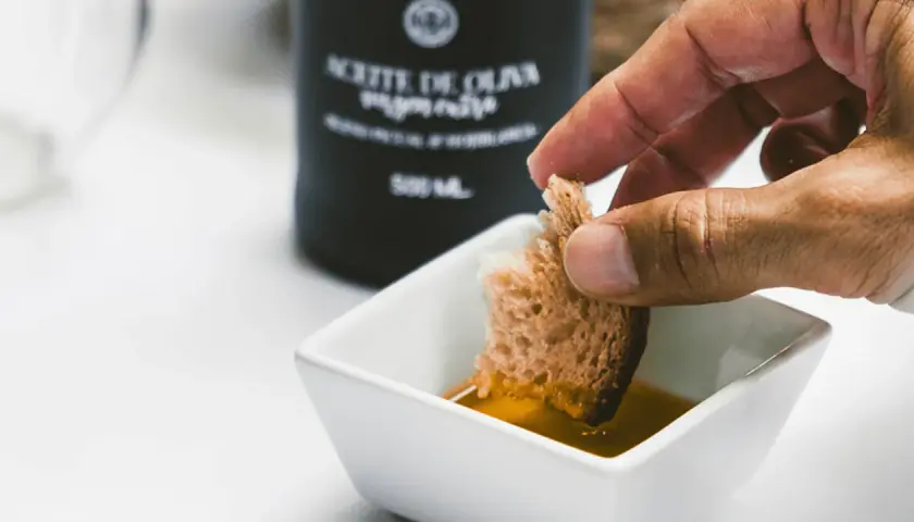 Pan mojado en aceite de oliva virgen extra (AOVE). Descubre qué es aove y para qué sirve: un placer para el paladar y la salud.