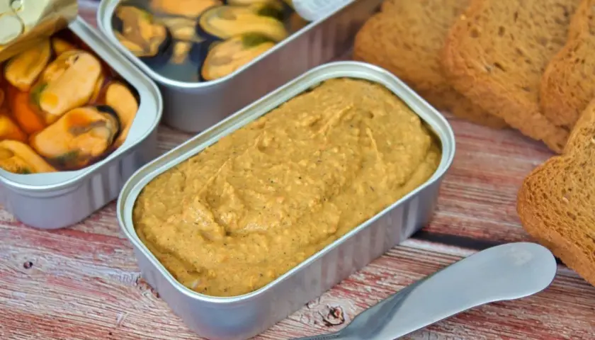 Pate de mejillones en lata, junto a mejillones en escabeche y tostadas.