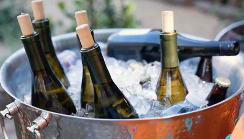 Botellas de vino blanco en cubitera de hielo, listas para disfrutar a la temperatura perfecta.