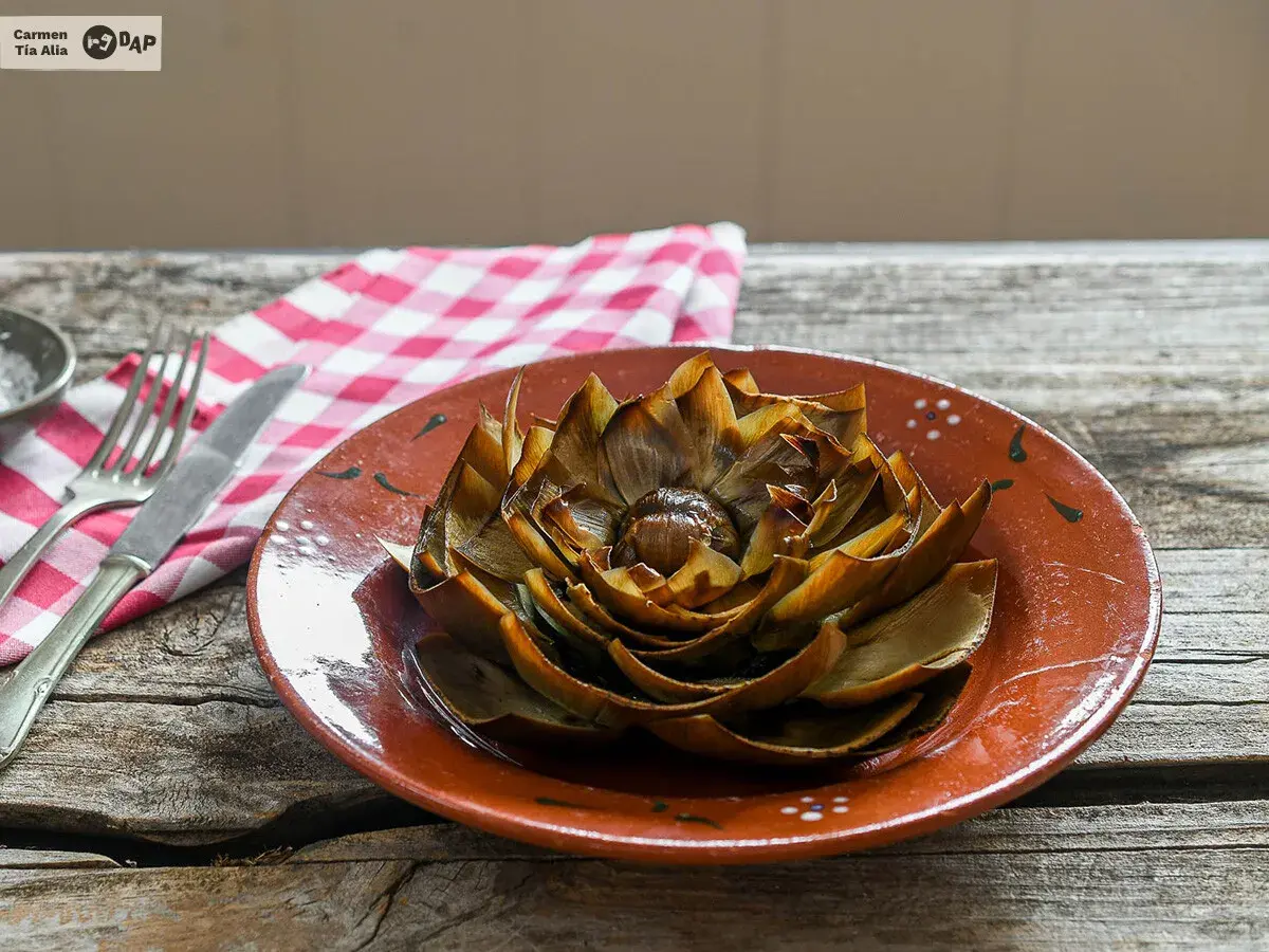 Alcachofas al horno, doradas y tiernas, listas para disfrutar en un plato rústico.