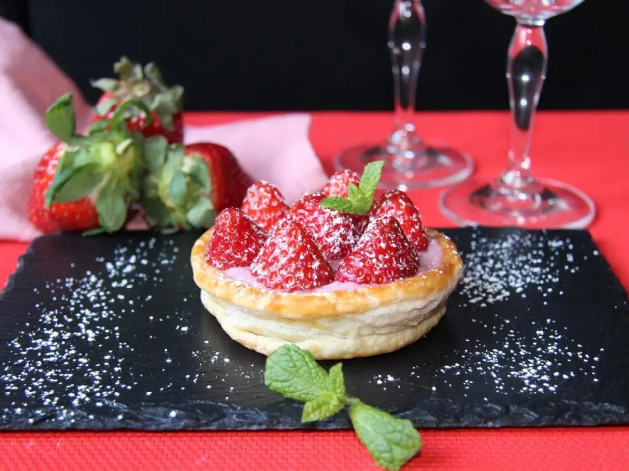 Tarta de fresas con crema rosa, espolvoreada con azúcar glas y menta. Perfecta para acompañar vinos de postre.