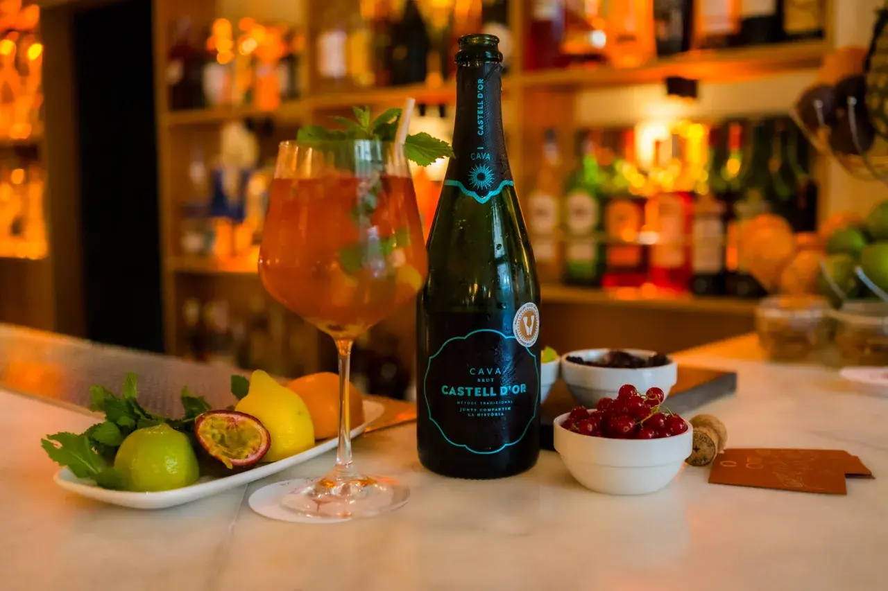 Refrescante sangría de cava con frutas y menta, lista para disfrutar.