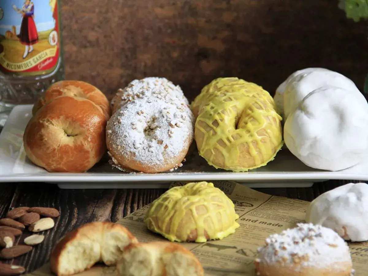 Rosquillas tontas, algunas cubiertas de azúcar glas y almendras, otras con glaseado amarillo y unas blancas. ¡Un dulce tentempié!