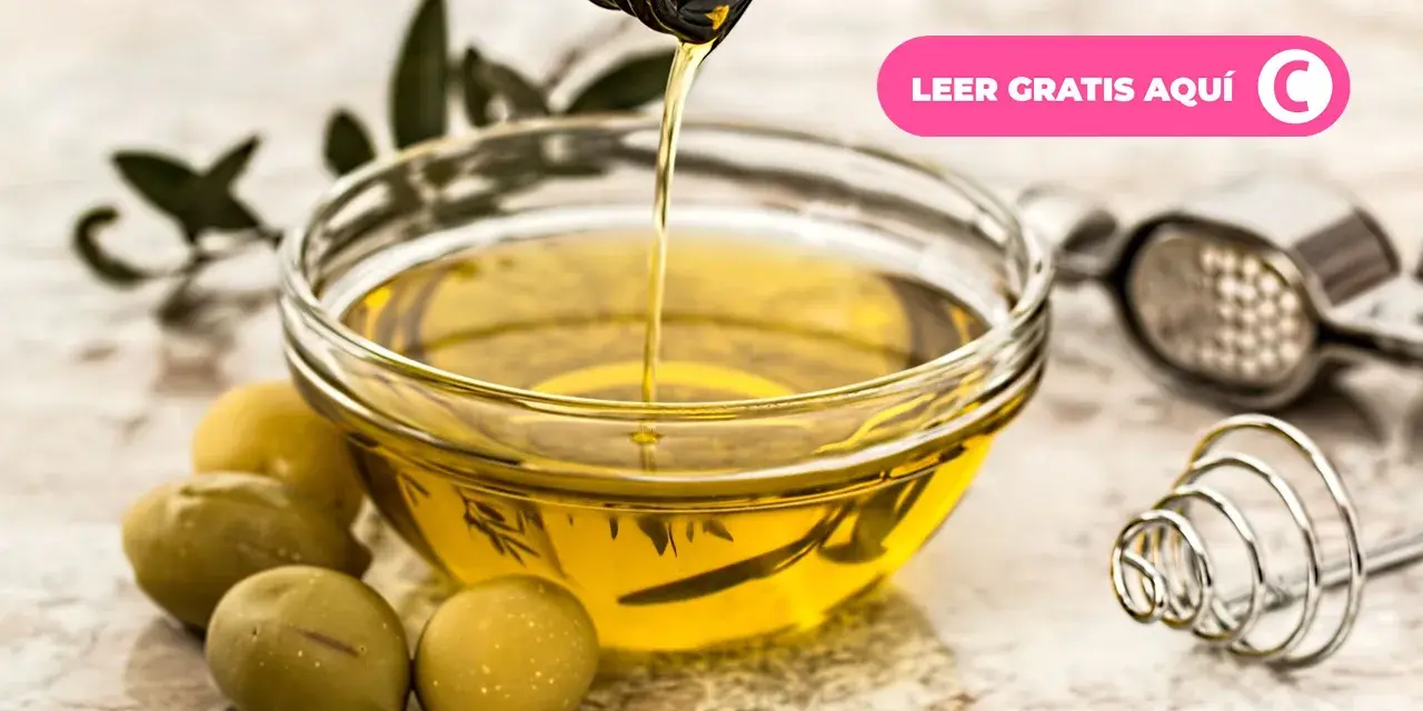 Aceite de oliva vertiéndose en un cuenco, rodeado de aceitunas y hojas de olivo. Descubre los múltiples usos del olivo.