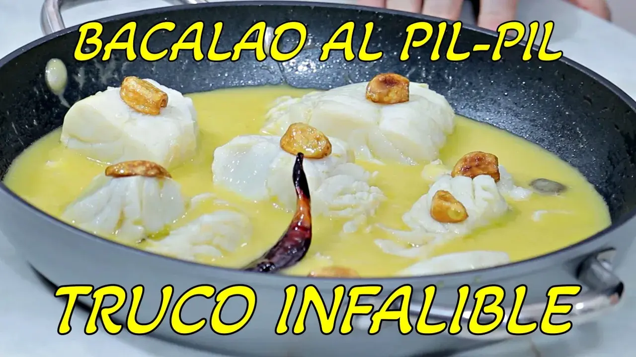 Bacalao al pil pil en sartén, con trozos de pescado blanco, ajos dorados y una guindilla. ¡La receta infalible!