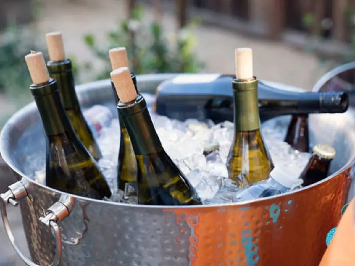 Botellas de vino blanco en cubitera de hielo, listas para disfrutar a la temperatura perfecta.