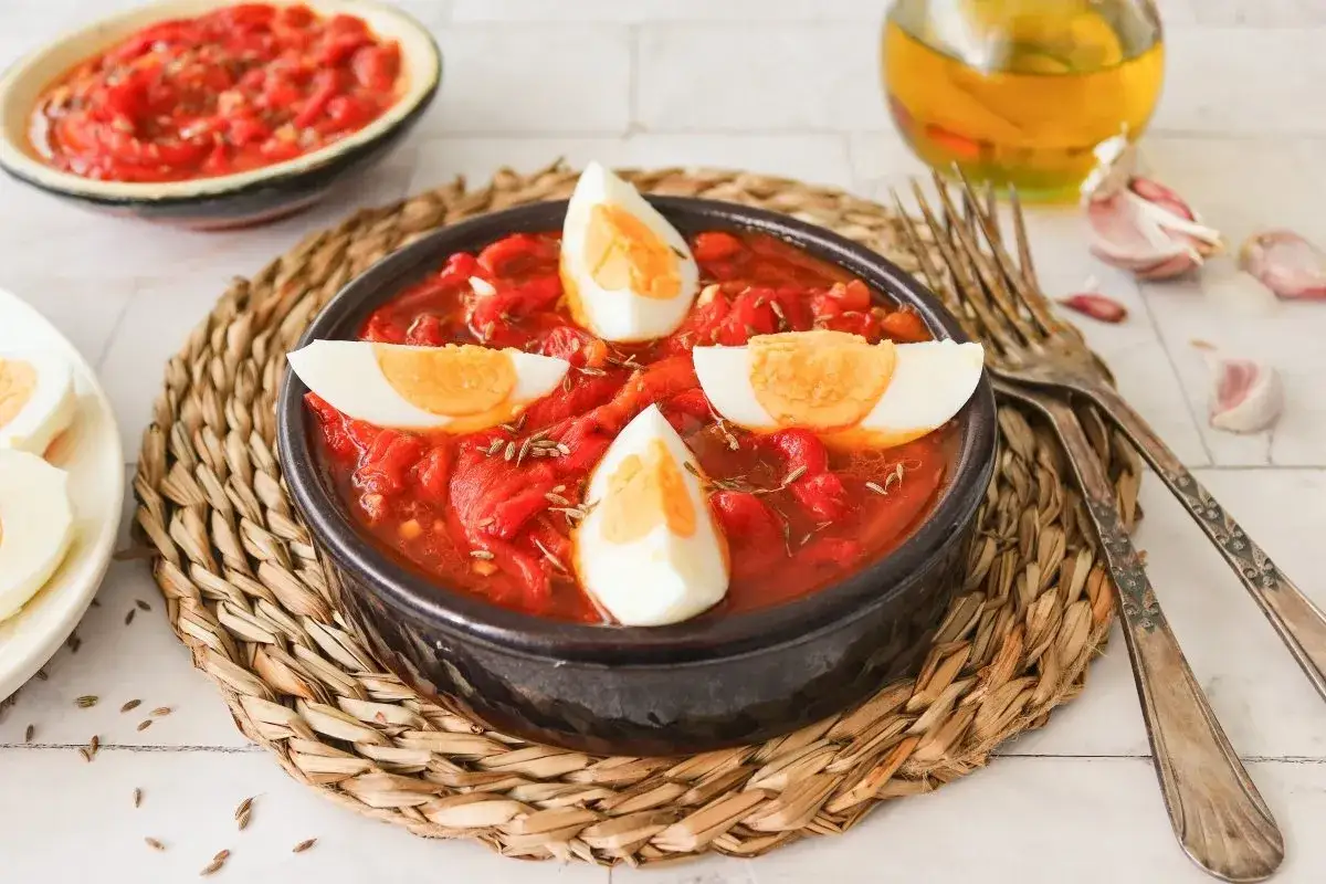 Un delicioso asadillo manchego, con pimientos rojos, huevo duro y especias, listo para disfrutar.