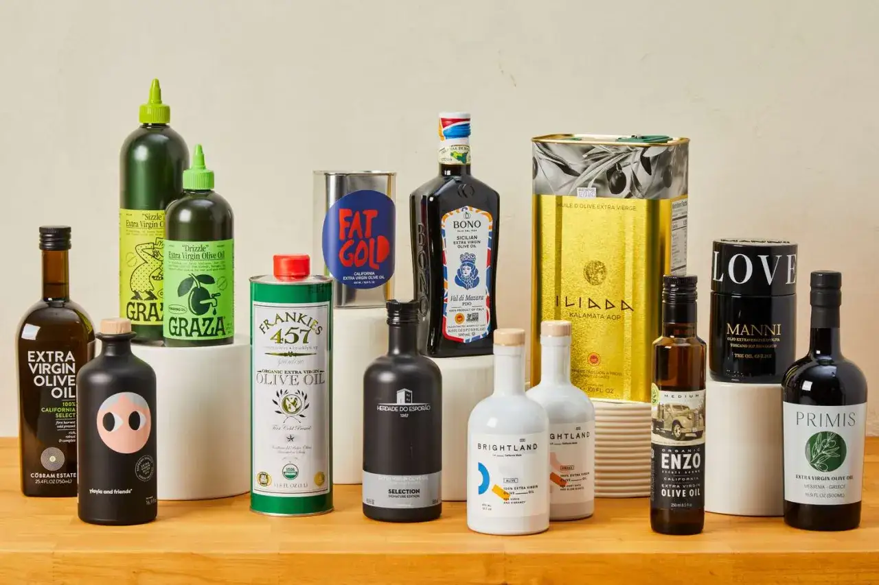 Variedad de aceites de oliva virgen extra, perfectos para encontrar el mejor aceite de oliva para cocinar. Botellas y latas de marcas como Graza, Frankies 457, Bono, Iliada y Enzo.